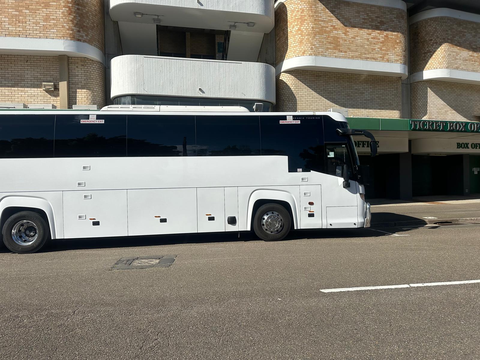 A full-size coach parked at the kerb, side view