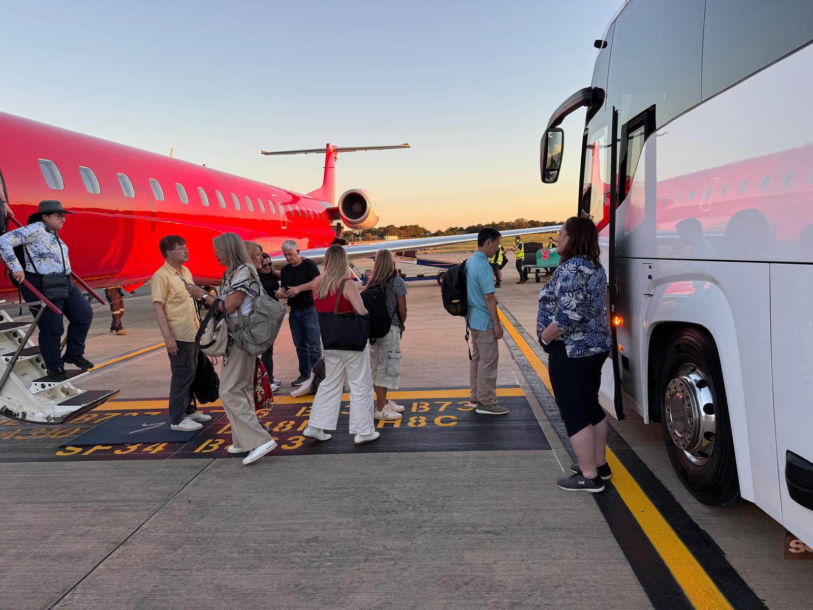 A driver assisting passengers with luggage